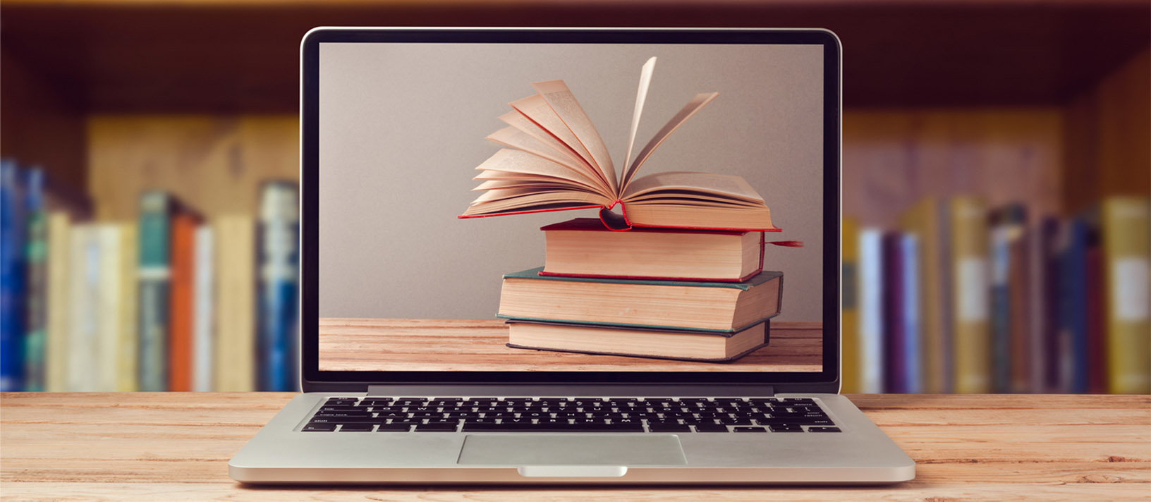 E-book library concept with laptop computer and stack of books on wooden table